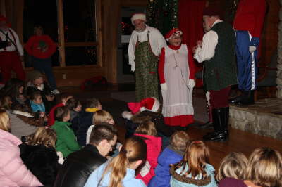 Santa, Mrs. Claus and and elf in front of children at the Nature Center